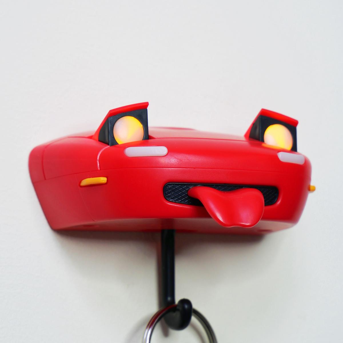 Red toy car-shaped keychain with a white background