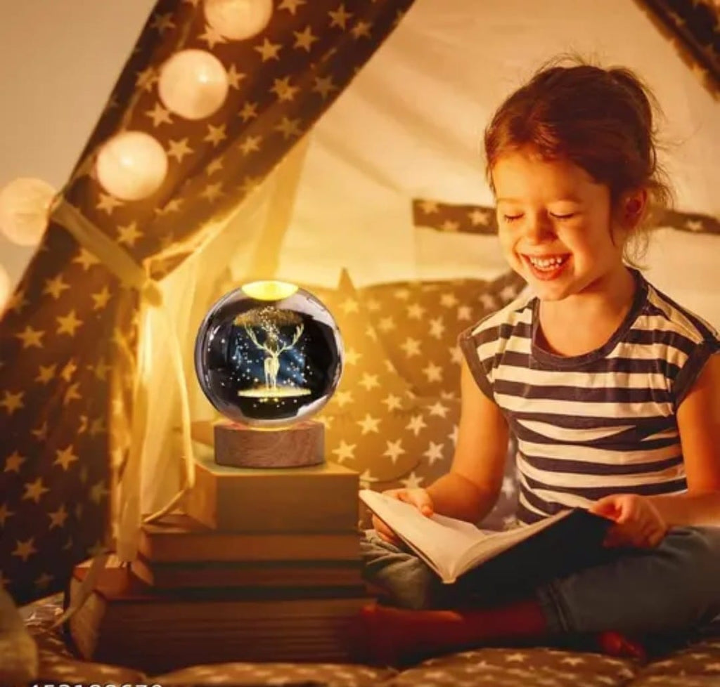 Child reading a book in a cozy tent with a glowing crystal ball on a stand.