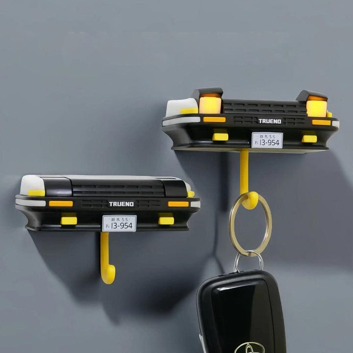 Two black and yellow wall hooks with a keychain on a gray background