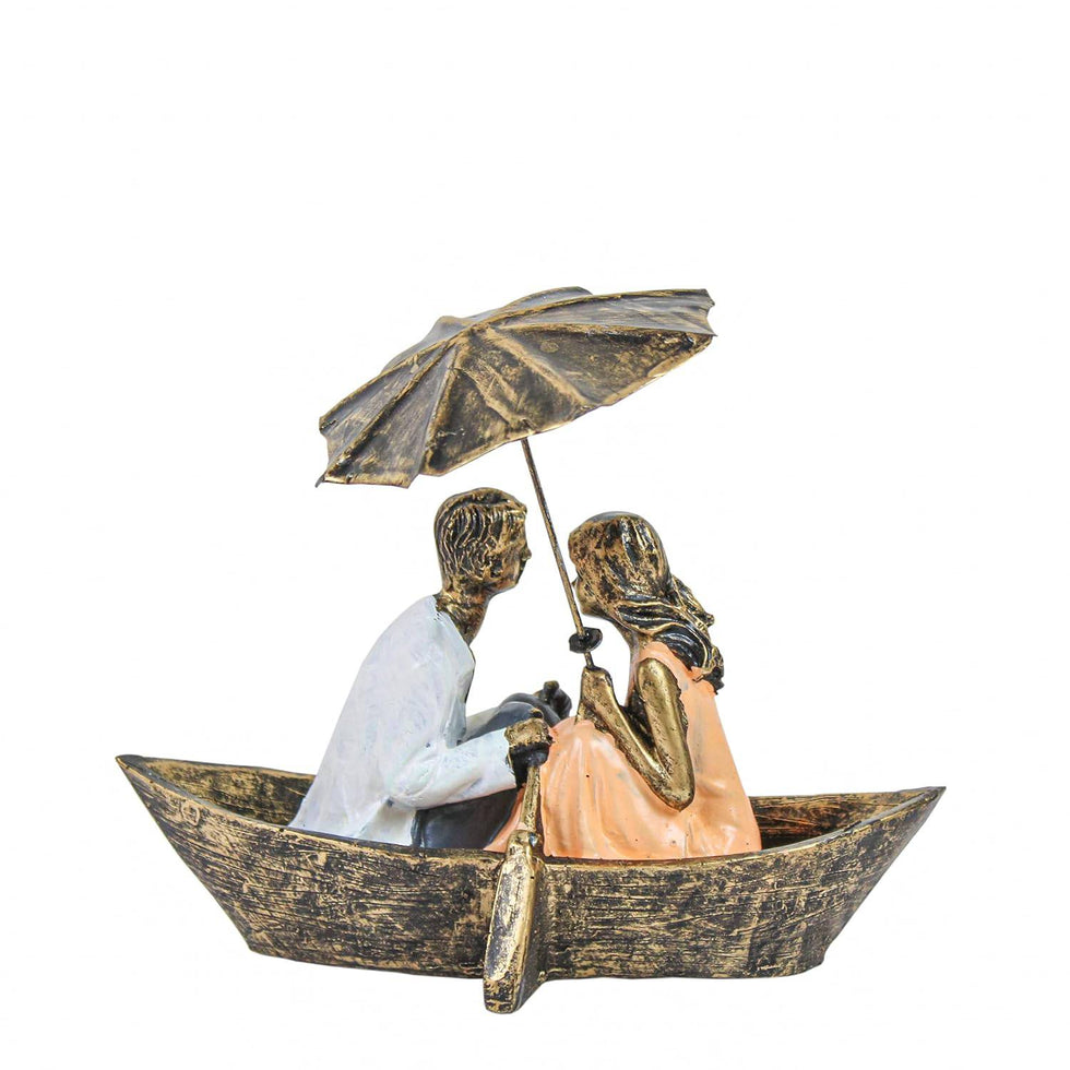 Statue of a couple in a boat under an umbrella on a white background