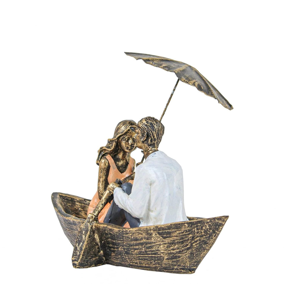 Statue of a couple in a boat under an umbrella on a white background